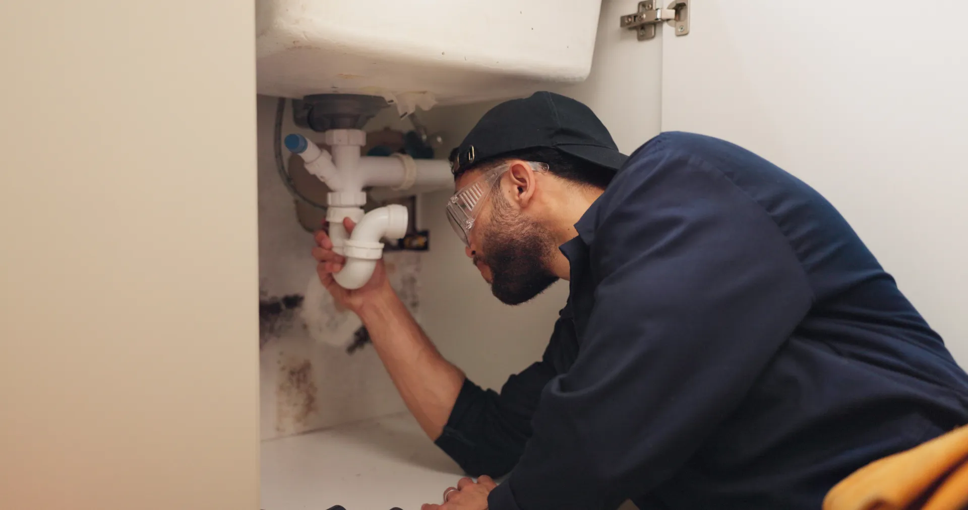 Plombier professionnel utilisant un furet électrique pour déboucher une canalisation